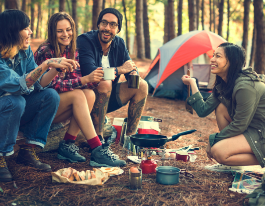 Happy campers sharing food and laughter surrounded by forest, enhanced by Good Friday Wellness Psilocybin Magic Mushrooms.