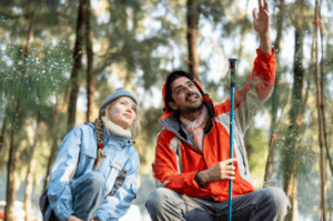 Hikers observing trees in forest