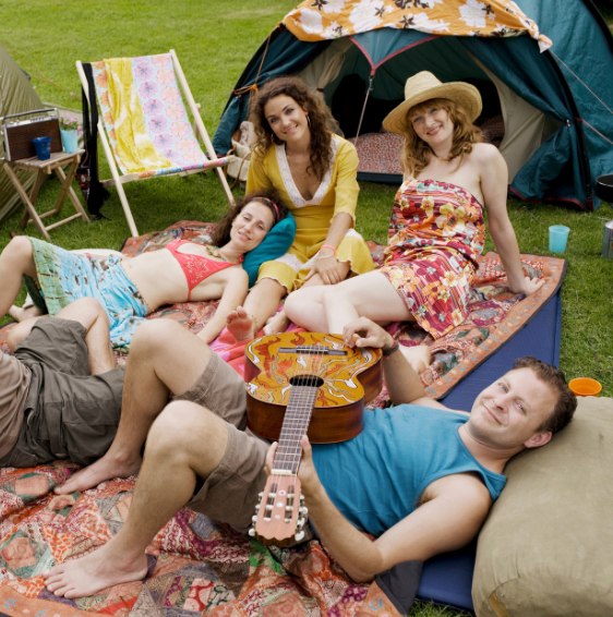 Group of friends relaxing on camping mats with a guitar, enjoying nature while using Good Friday Wellness magic mushroom capsules in Canada