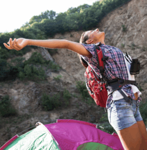 Woman stretching in front of a colorful tent, uplifted by Good Friday Wellness magic mushrooms