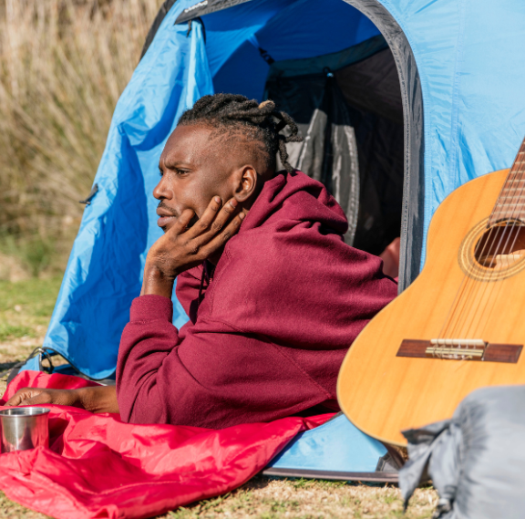 Group camping with guitar outside tent