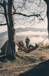 Hammocks between trees with a misty mountain backdrop