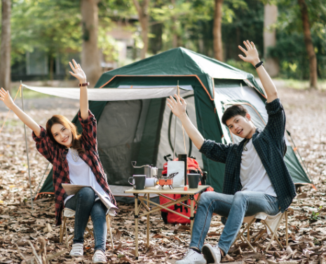 Campers stretching joyfully near tent with Good Friday Wellness magic mushrooms.