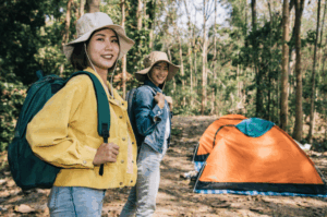 Smiling hikers near campsite with Good Friday Wellness magic mushrooms.