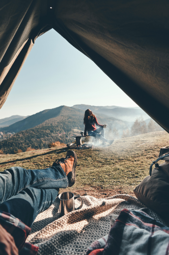 Relaxing tent view of serene mountains and campfire, enhanced by Good Friday Wellness magic mushroom capsules.