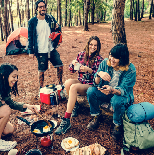 Friends enjoying breakfast in the forest, laughing and bonding with Good Friday Wellness magic mushroom capsules.