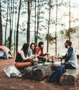 Group laughs and connects during camping trip enhanced by Good Friday Wellness magic mushroom delivery.