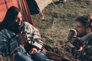 Couple enjoying a serene mountaintop campfire experience with Good Friday Wellness magic mushrooms