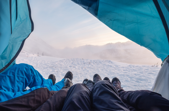 Group of friends relaxing and laughing outside a tent