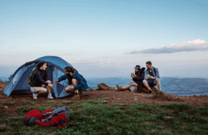 Couples camping on a mountaintop at sunset — Good Friday Wellness magic mushroom capsules journey