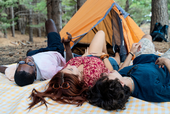 Friends relaxing outdoors near a tent on a picnic blanket — Good Friday Wellness magic mushroom capsules experience