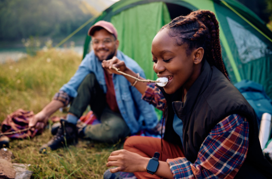 Woman roasting marshmallows while camping.