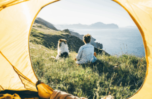 Woman and dog enjoy ocean view from tent – Good Friday Wellness magic mushrooms