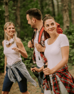 Three young adults laughing while walking in the forest with the help of Good Friday Wellness Psilocybin Magic Mushrooms.