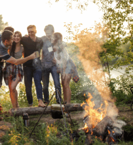 Group of friends toasting by a glowing campfire – Good Friday Wellness magic mushrooms