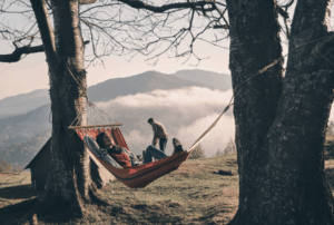 Person relaxing in a hammock between trees with a mountain view – Good Friday Wellness Psilocybin Magic Mushrooms