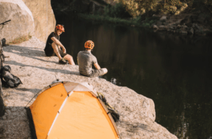 Campers enjoying riverside calm with Good Friday Wellness magic mushroom capsules